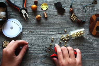 siyah bir iş parçacığı üzerinde el yapımı renkli boncuklar ahşap bir masaya yalan 