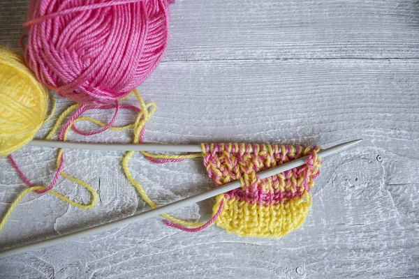Agulhas de tricô e um fio colorido na mesa — Fotografia de Stock