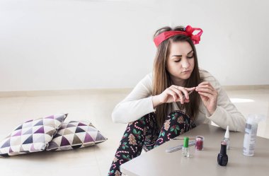 genç güzel kız manikür yaparken başında kırmızı bir yay ile