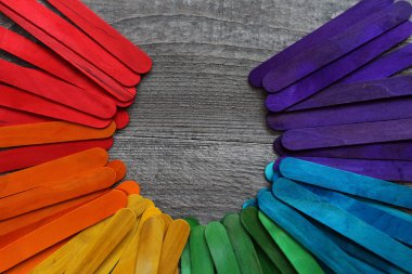 ahşap bir masa üzerinde farklı renklerde boyanmış ahşap sopa