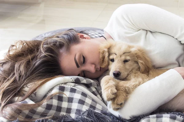 Young pretty girl sleeps with puppy on the blanket — Stock Photo, Image