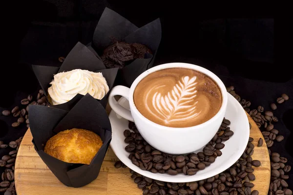 Вкусный кофе и различные кексы и кексы на деревянном подносе . — стоковое фото