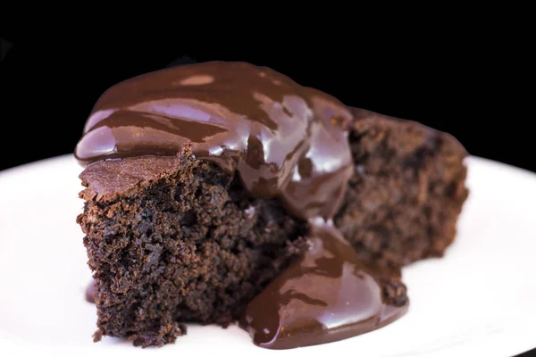 Brownie de chocolate com molho de chocolate quente derretendo sobre ele . — Fotografia de Stock