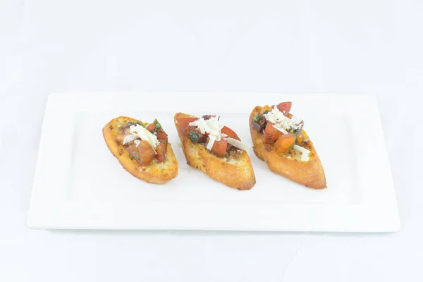 Tres bruschettes con queso de tomate y hierbas y ajo servido — Foto de Stock