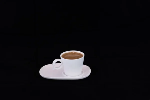 Caneca de café turco quente em um pires em um fundo preto — Fotografia de Stock