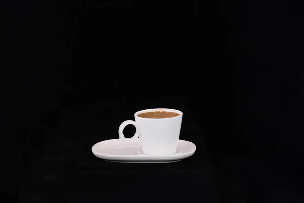 Mug of hot Turkish coffee on a saucer on a black background — Stock Photo, Image