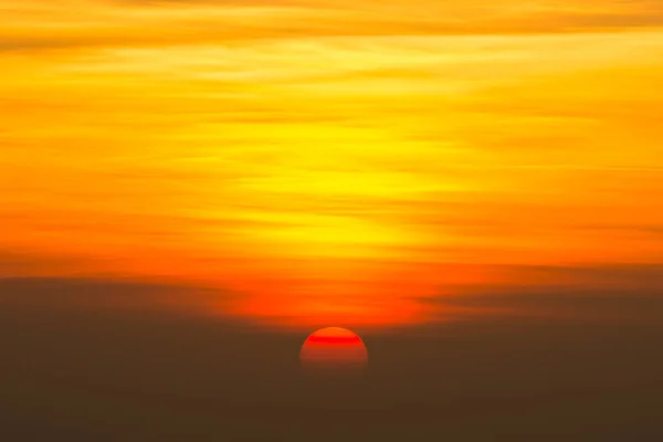 空の日没時に美しいビッグサン 黄色と赤とオレンジの色の色合いと良い夜の天気 — ストック写真