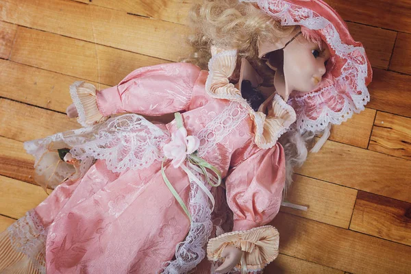 Broken doll on a wooden floor. — Stock Photo, Image