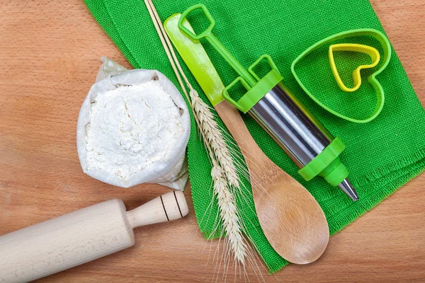 Flour with wheat ears, pastry syringe and baking molds. — Stock Photo, Image