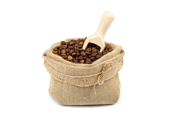 Granos de café en bolsa de lona con cuchara de madera — Foto de Stock