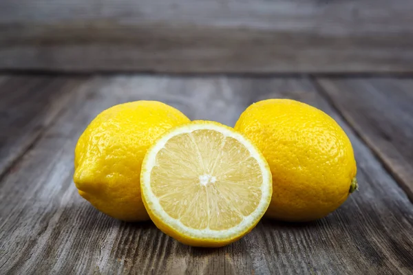 Frische Zitronen auf einem hölzernen Hintergrund — Stockfoto