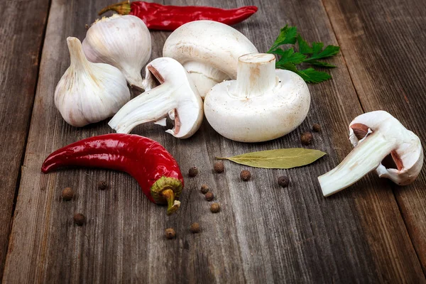 Champignons, ail, piments rouges, épices sur un bois — Photo