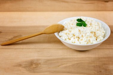 Kaşık ile beyaz bir kase taze peynir