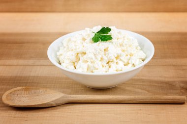 Kaşık ile beyaz bir kase taze peynir