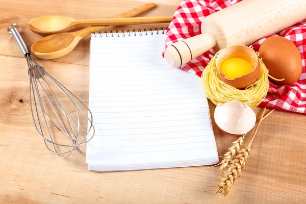 Keukengerei, ei en laptop voor recepten op een houten — Stockfoto