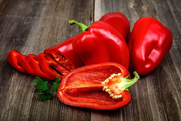 Slices of red bell pepper on a wooden background — Stock Photo, Image