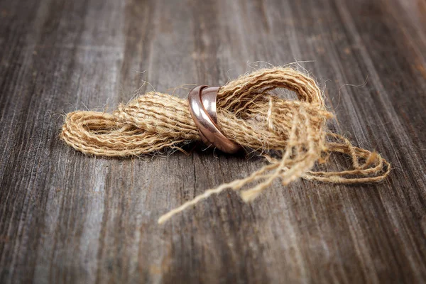 Ahşap bir arka plan üzerinde nikah yüzükleri vardır