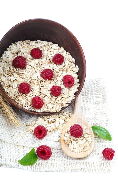 Oatmeal flakes and raspberries on white background. — Stock Photo, Image