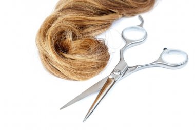 Profesyonel kuaför makası ve sarışın saç.