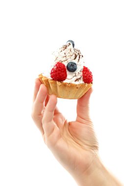 Taze yaban mersini ve ahududu kremalı pastada, beyaz arka planda izole edilmiş bir kadın elinde..