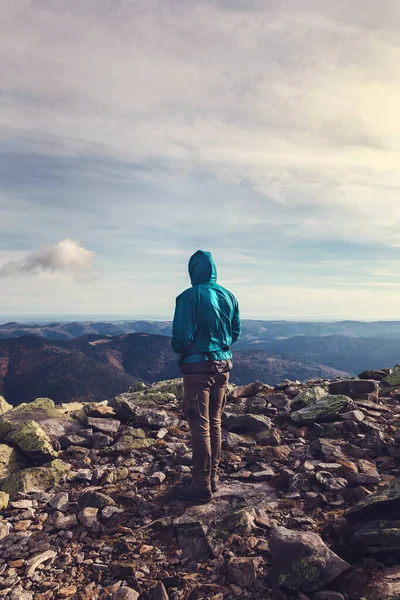Genç üzgün gezgin bir dağın tepesinde duruyor..