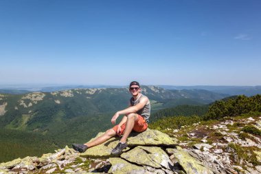 Genç adam bir dağın tepesinde seyahat ediyor..