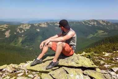 Genç adam bir dağın tepesinde seyahat ediyor..