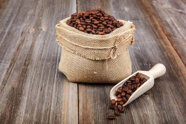 Kávová Zrna Plátěné Tašce Dřevěnou Kopečkou Dřevěném Pozadí — Stock fotografie
