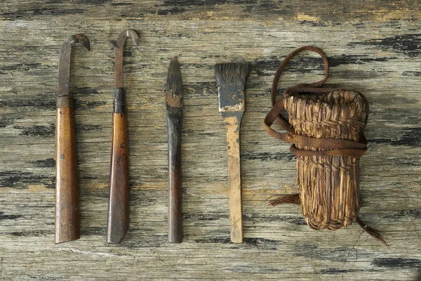 Антикварные режущие инструменты на деревянной пластине — стоковое фото