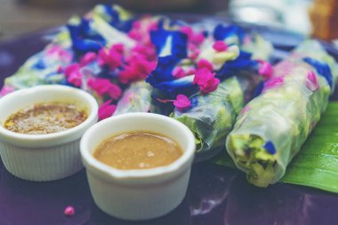 Taze marul ve Tay otlar, salatalık, Marine havuç pirinç kağıdına sarılı Pirinç Noodle ile rulo ve Fıstık soslu muz çiçeği ile gösterilir.