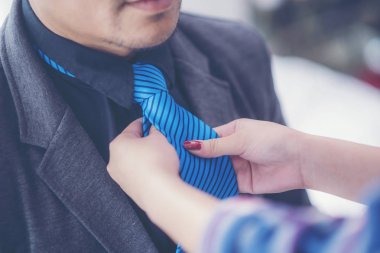 işadamı hazırlamak proje ve kravat ayarlamak için asistanı yardım sunmak için gitmek