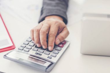 Sayıları hesaplamak için bir hesap makinesi kullanarak iş adamı. Hesap oluşturma