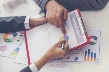 Finansal kağıt çizelgeleri ve grafikler masada.