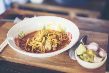 Khao Soi, yerel Kuzey gıda Tayland güzel bir dizi. Khao soi üzerine kızarmış şehriye ile köri ile tavuk. Geleneksel yan yemekler ile yemek.