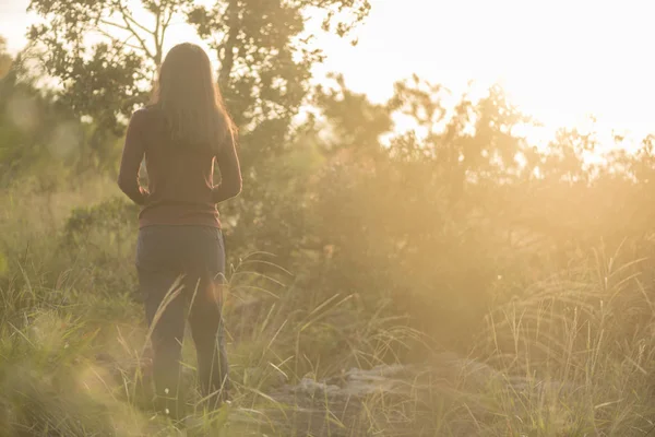 Gün batımında ormanda genç bir kadın 