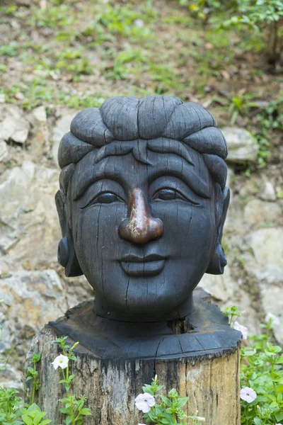 wooden carving sculpture with a face of buddha
