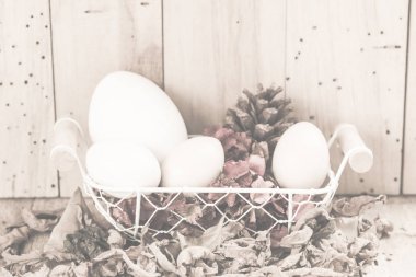 ahşap arka plan ile bir sepet içinde paskalya yumurtaları, vintage filtreli Görüntüler
