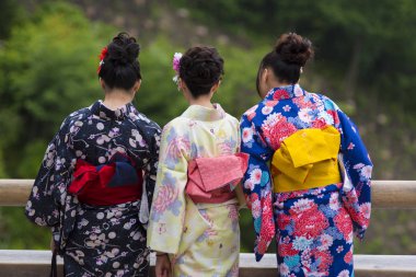 Kyoto, Japonya - 25 Kasım 2015: Kadın turizmi, 25 Kasım 2015 tarihinde Kyoto 'ya seyahat etmek için Kimono adlı geleneksel bir elbise giyiyor.