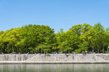 Hiroşima, Japonya - 10 Temmuz 2015: Barış Ateşi 'nin arkasındaki Hiroşima Barış Anıt Müzesi. Müze Hiroşima Barış Anıt Parkı 'nda bulunmaktadır ve 1955 yılında kurulmuştur..