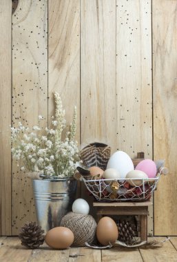 Tahta bir arka planda sepetteki paskalya yumurtaları