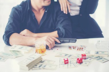 Gambling business concept, man with gun at gambling table