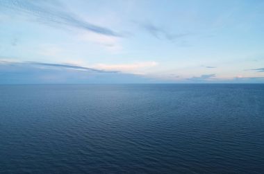 ufuk deniz mavi bir yüzey üzerinde bırakarak bulutlu mavi gökyüzü