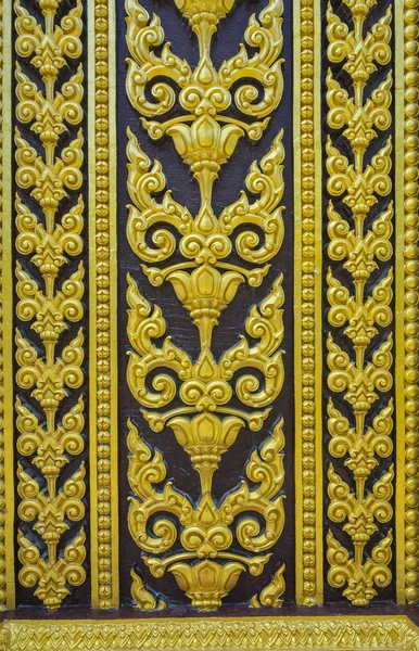 Temple door decorated with gold leaf designs Thailand