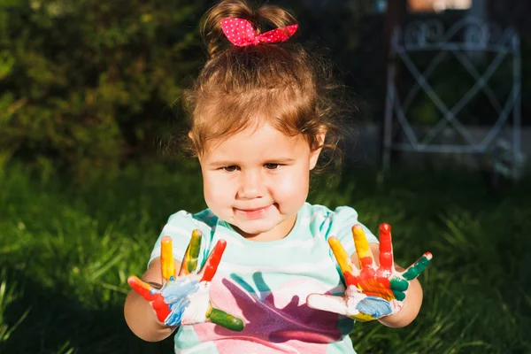 Malá dívka ukazuje malované barevné ruce — Stock fotografie