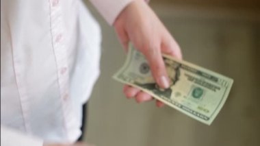 Kadın para onun elinde sayar.