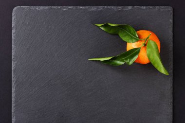 Siyah arduvaz taş zemin üzerine portakal mandarin