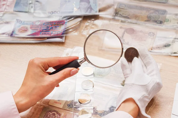 Parayı bir büyüteç aracılığıyla kadın bakar