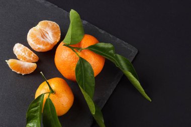 Siyah arduvaz taş zemin üzerine portakal mandalina