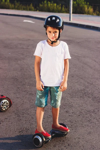 男孩站在户外黑色陀螺滑板车上 — 图库照片