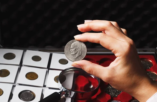 Женщина смотрит на долларовую монету — стоковое фото